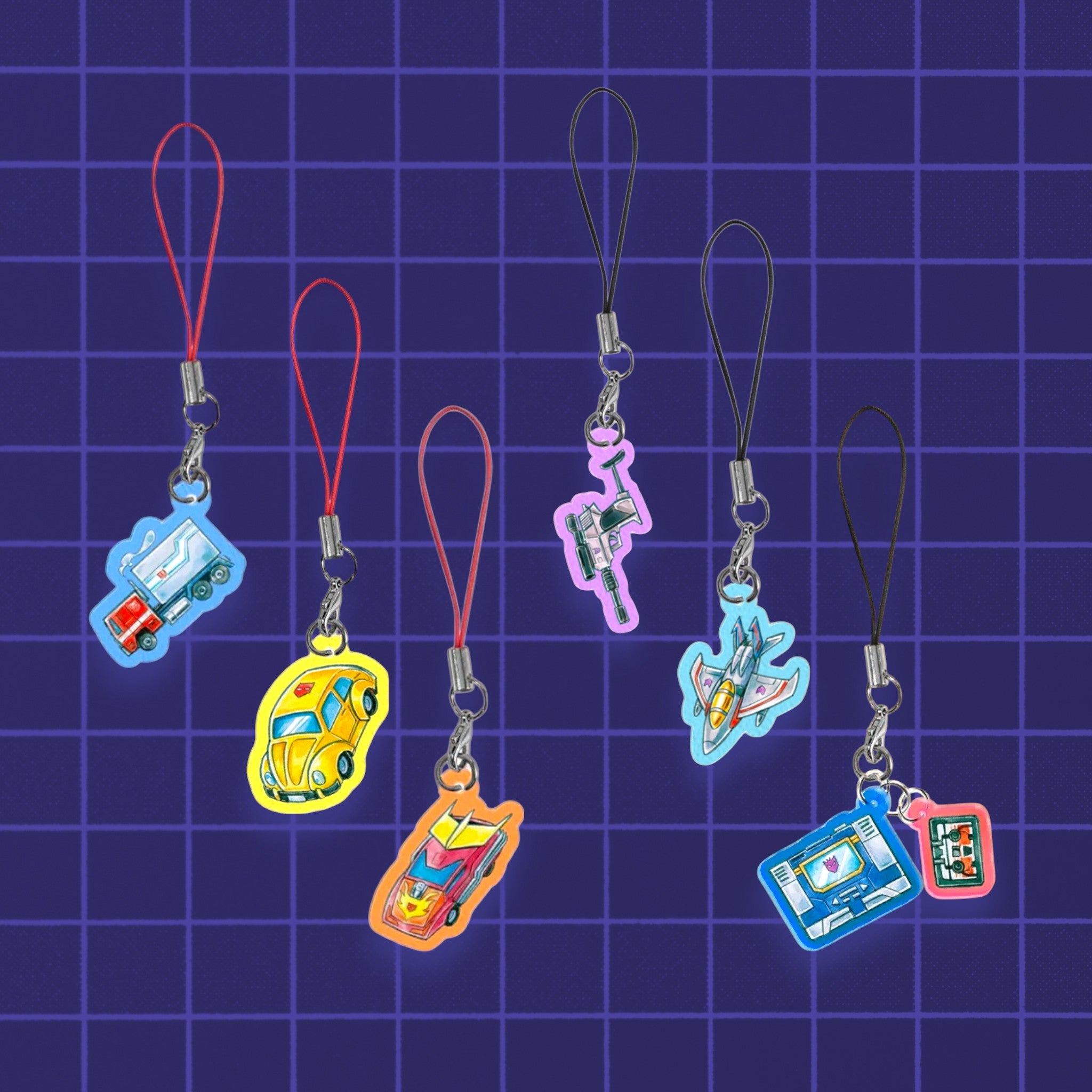 Godliath 1-inch acrylic Alt Mode phone charms featuring colorful Transformers vehicle designs on a grid background.