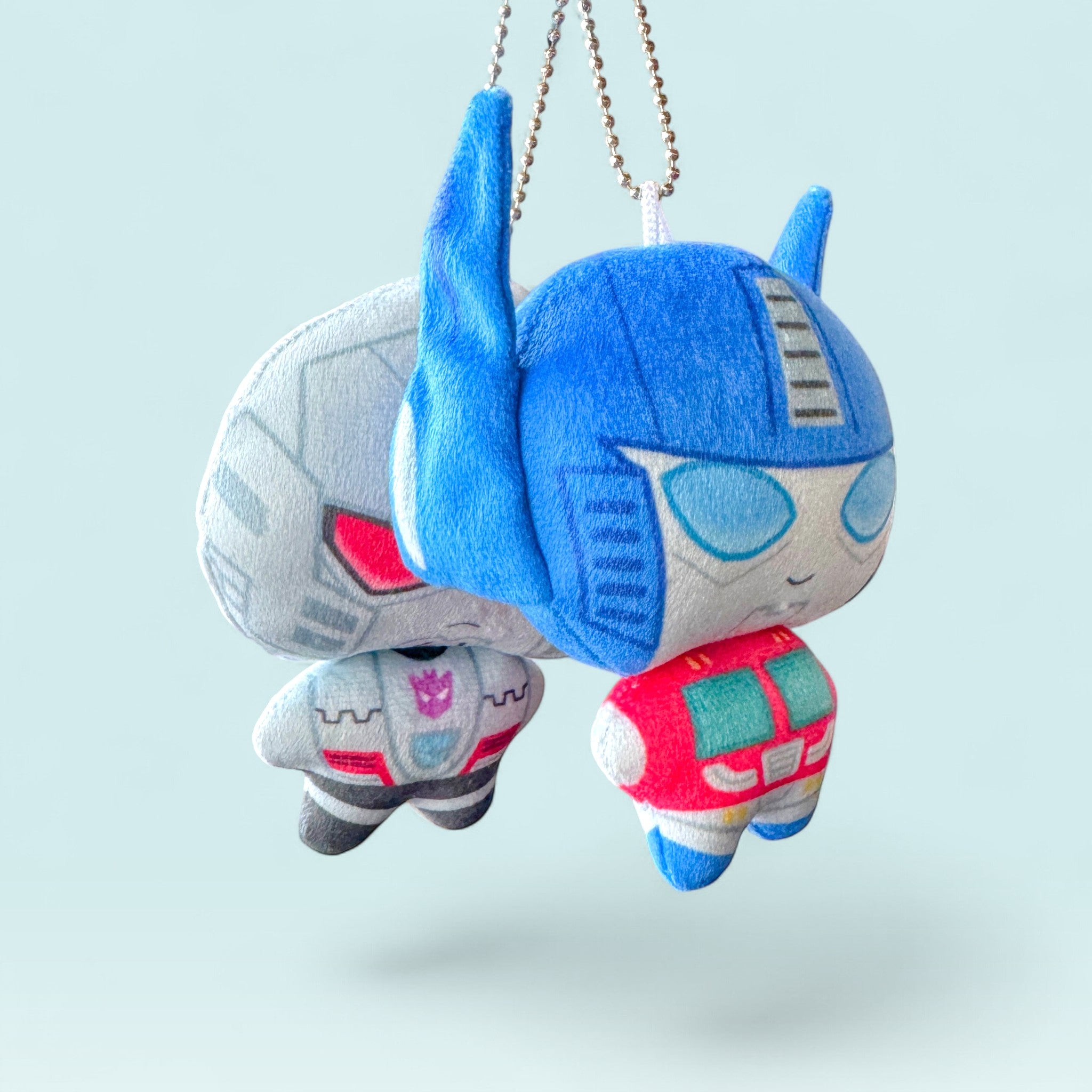 Godliath 4-inch plush charms featuring stylized robot characters with silver ball chain clasps on a light blue background