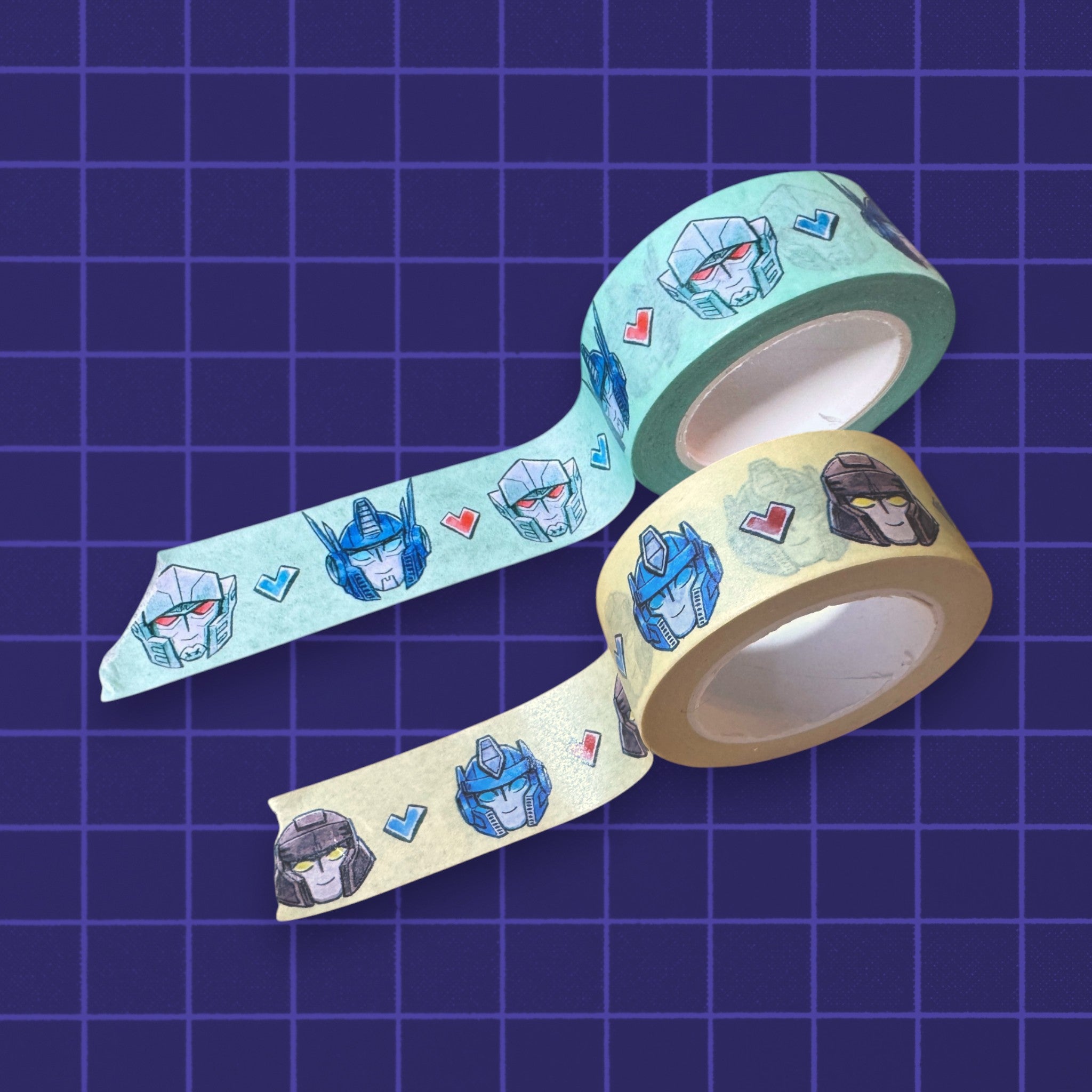 Godliath decorative washi tape rolls featuring illustrated robot character heads and hearts on light blue and tan paper
