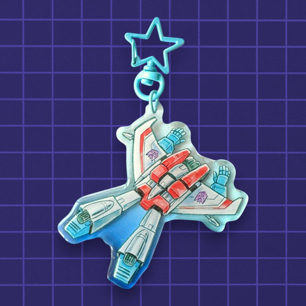 Godliath acrylic keychain featuring a chibi robot jet character with a blue star-shaped clasp on a grid background.