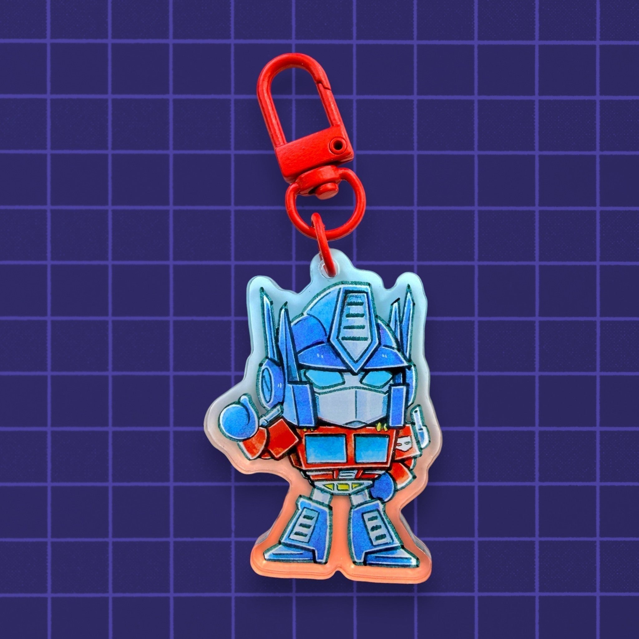 Godliath Tinybots G1 Optimus Prime acrylic keychain with a translucent gradient effect and red lobster clasp.